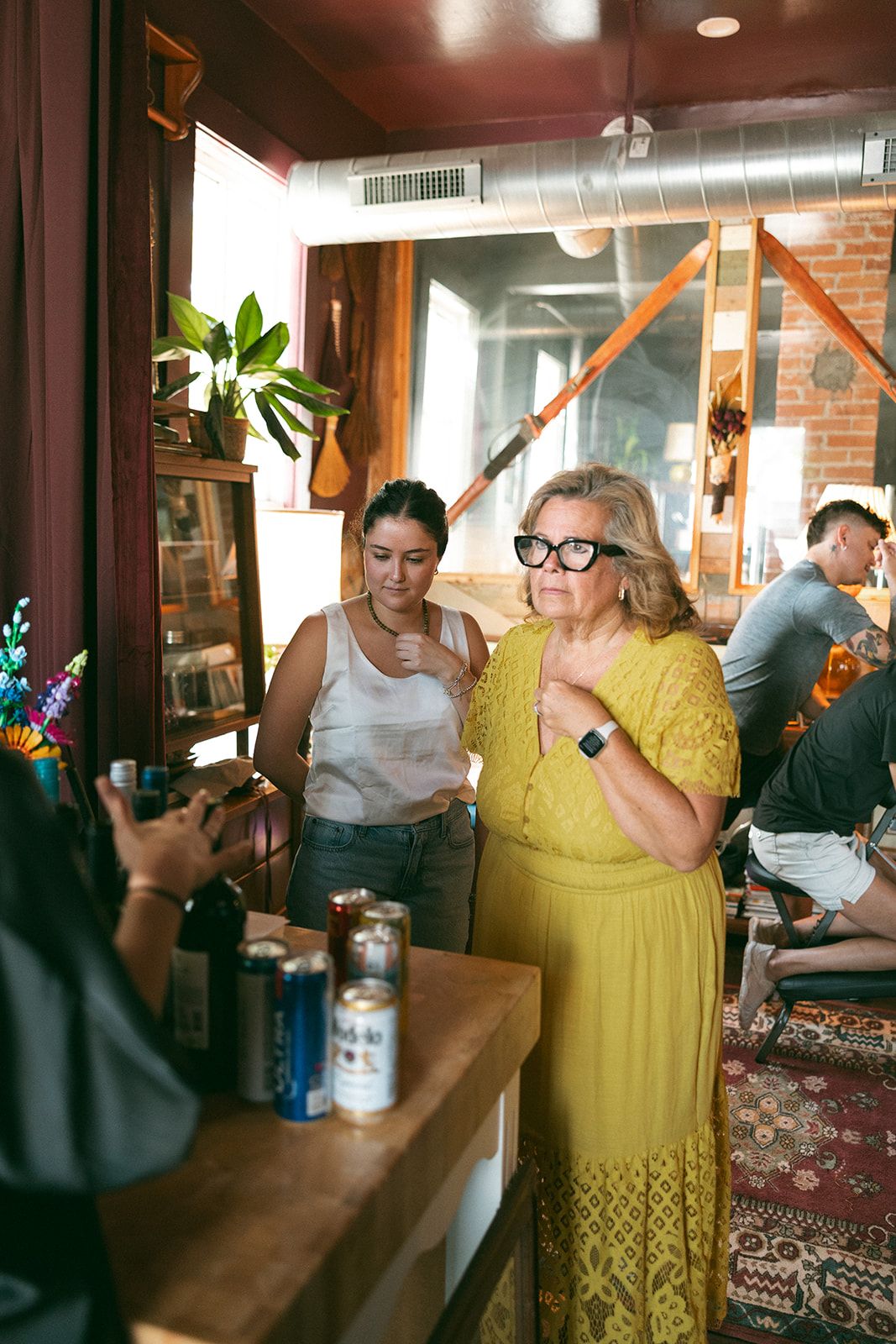 Guests chatting in a salon, a woman in a yellow dress in the middle