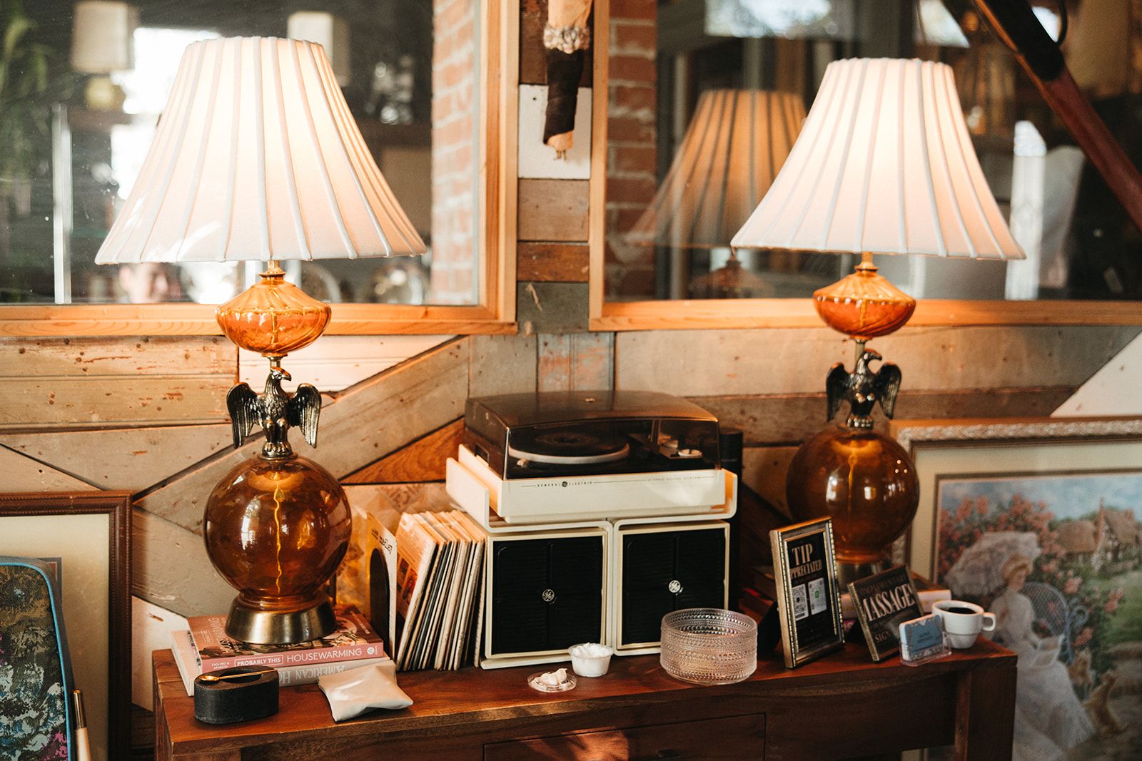 A record player between two amber glass lamps