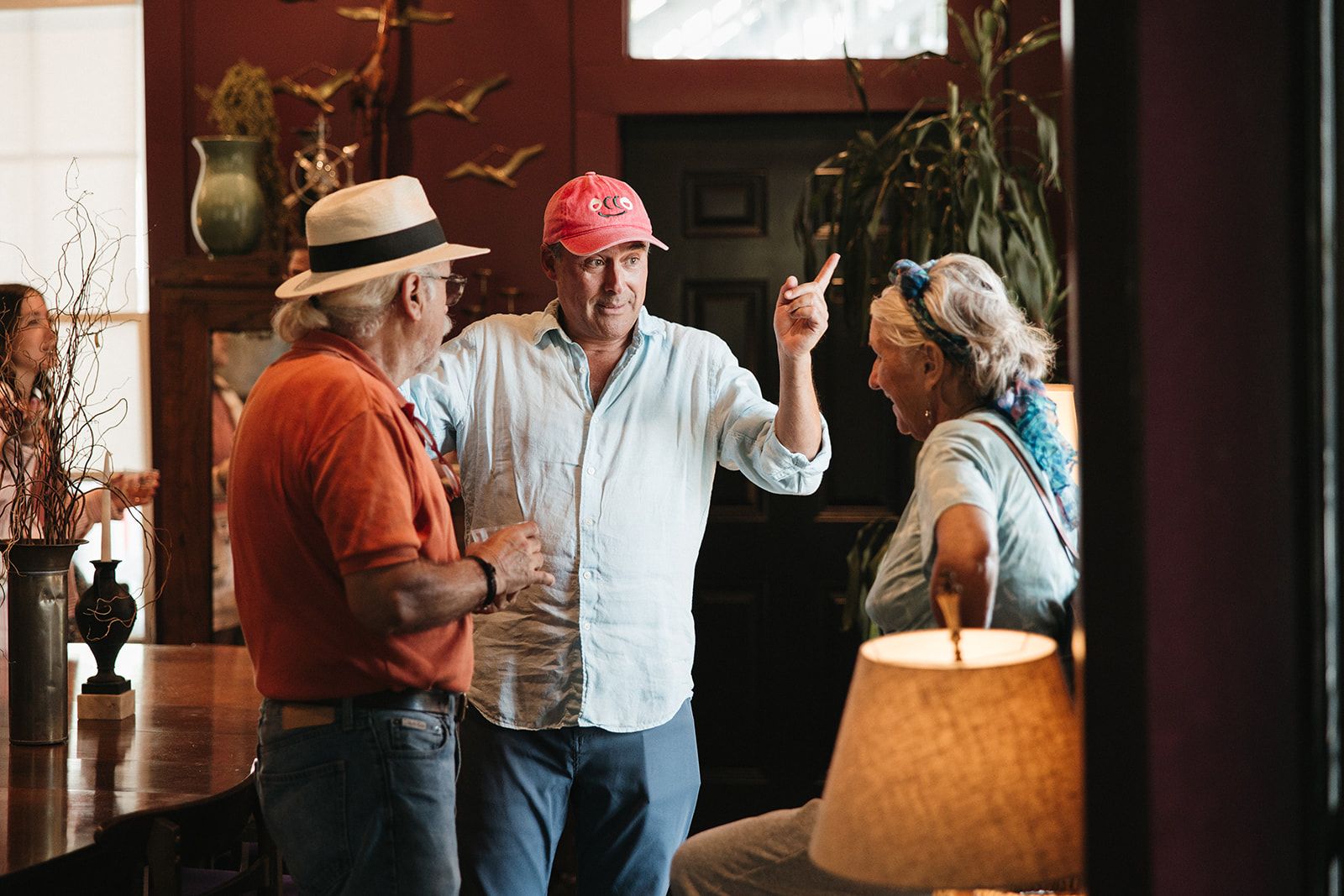 Three guests laughing together in a dining room
