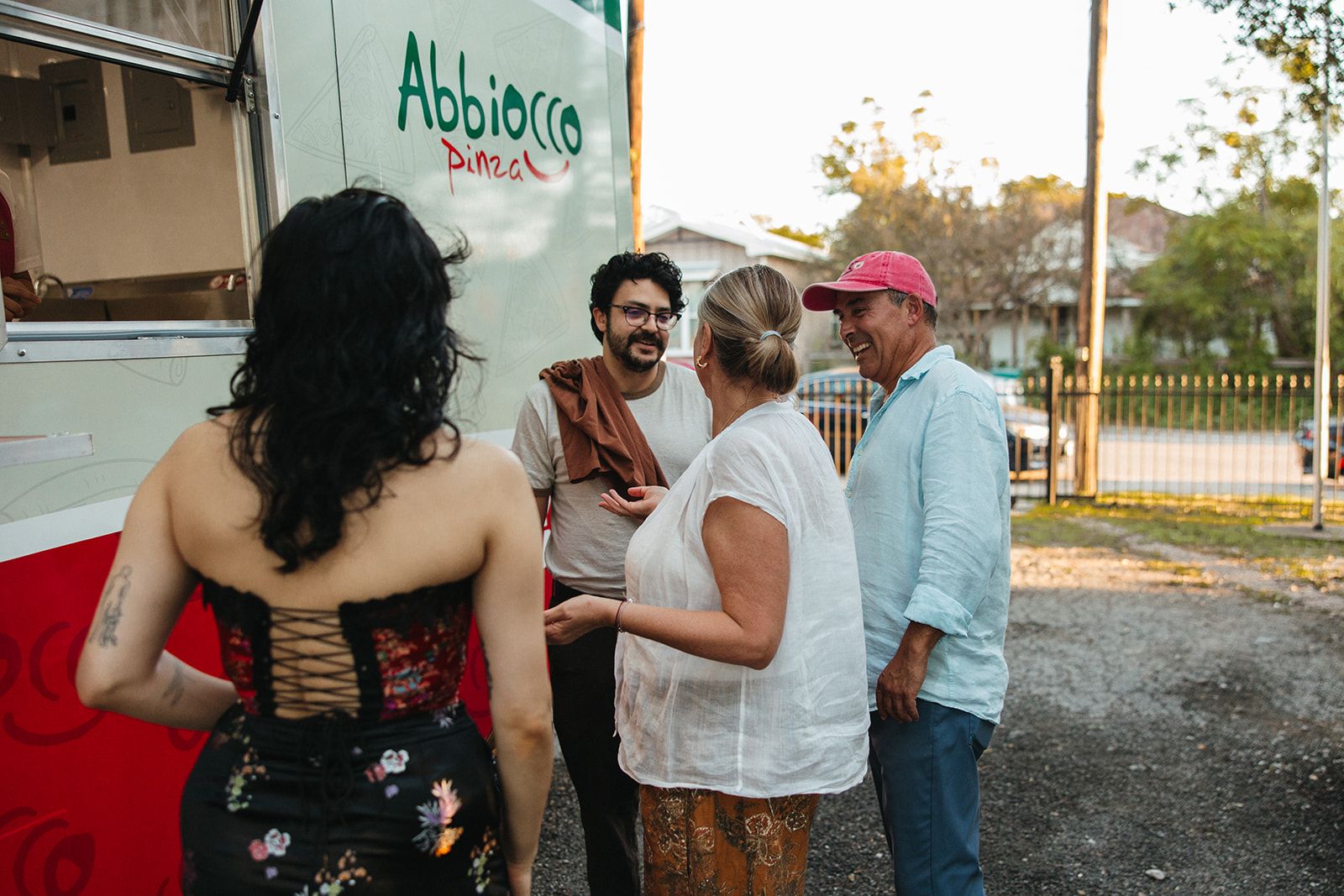 Guests chatting near a pizza truck in the yard