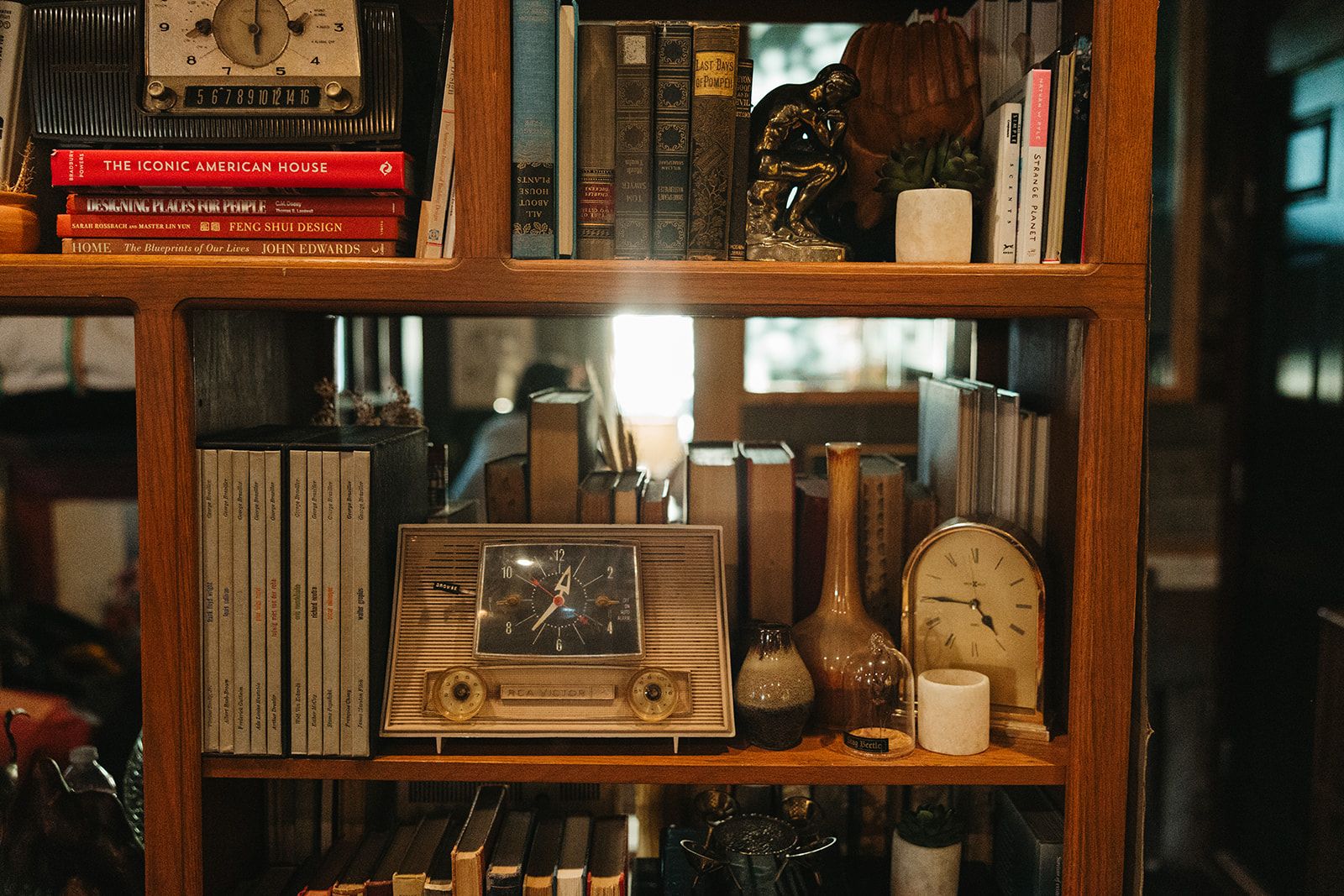A wooden bookshelf with a vintage radio and books