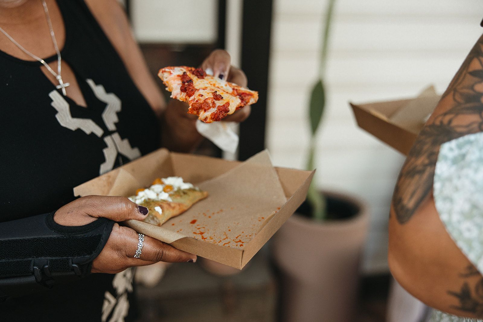 Hands holding slices of pizza
