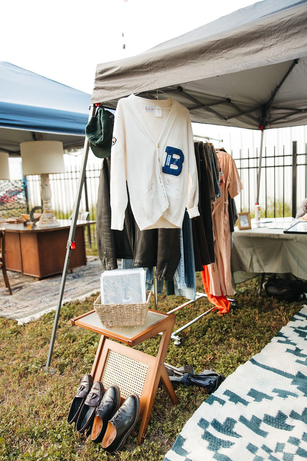 A market booth with a clothes rack standing on a rug