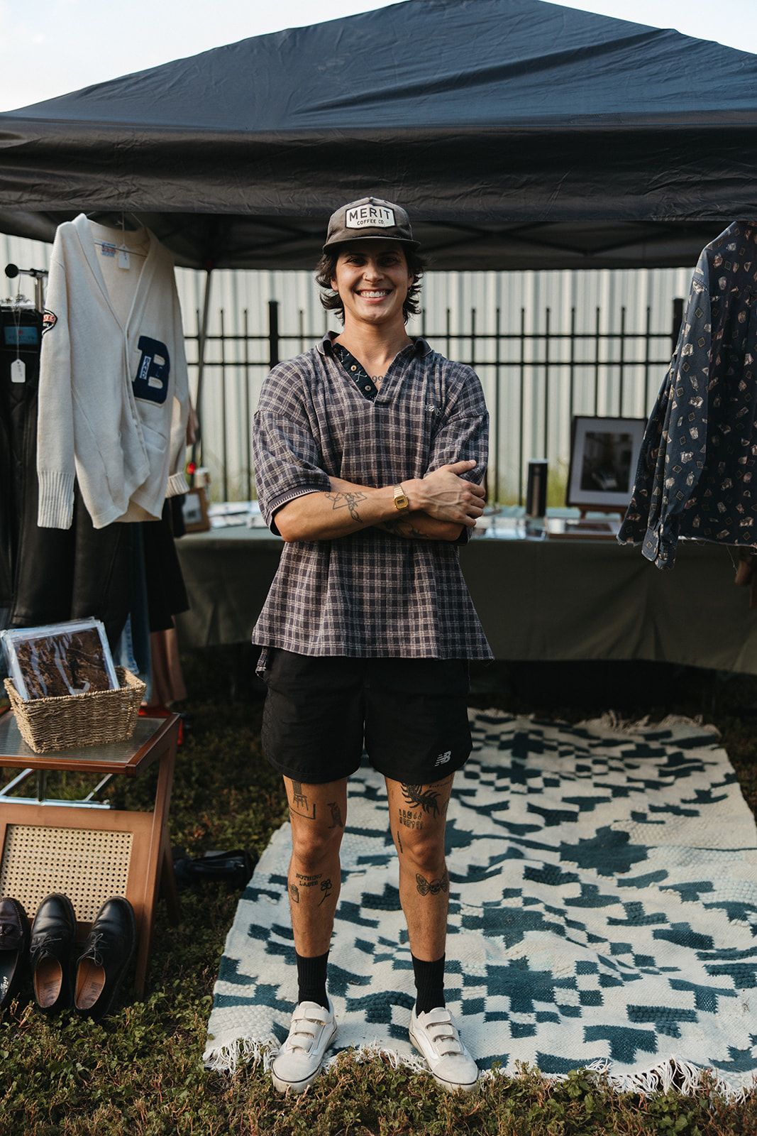 A vendor standing at a booth set on a rug