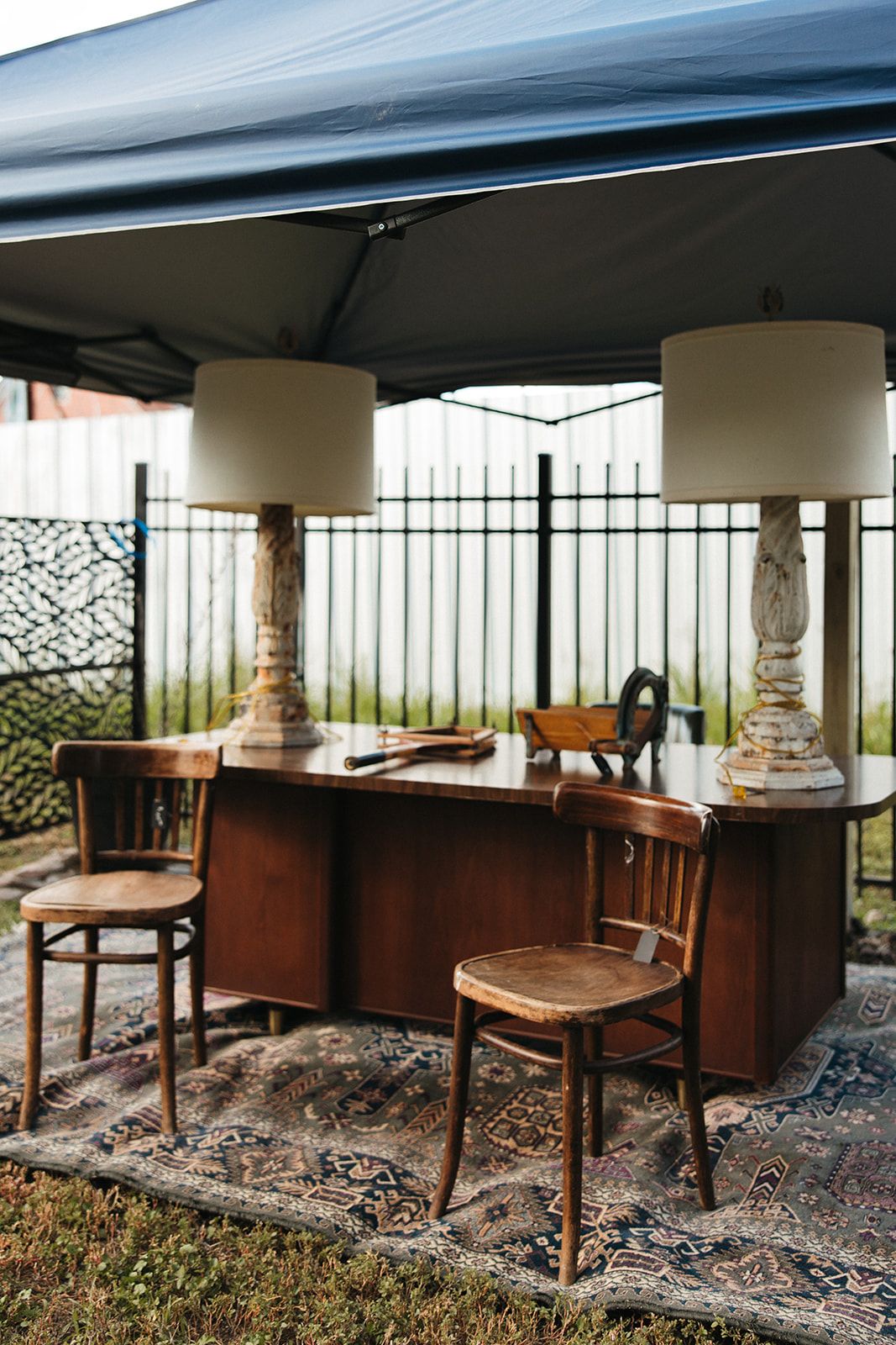 A vintage desk set up as a booth under a canopy