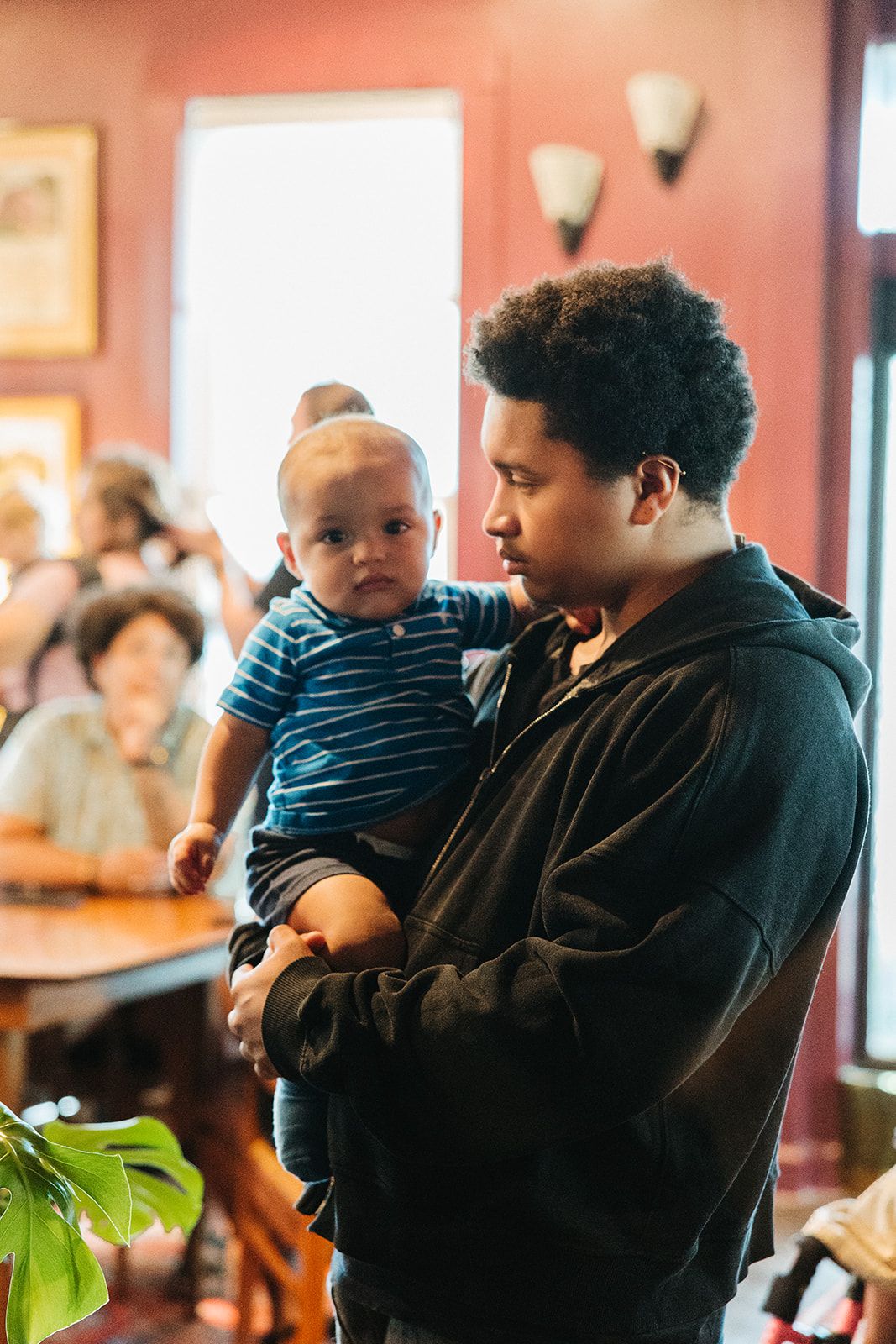 A father holding his baby indoors