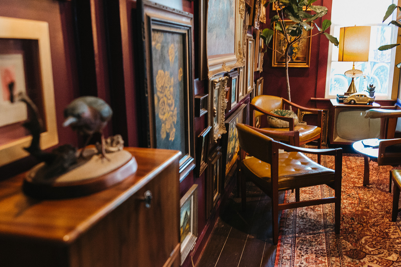 Leather chairs in a lounge corner with a gallery wall and lamplight